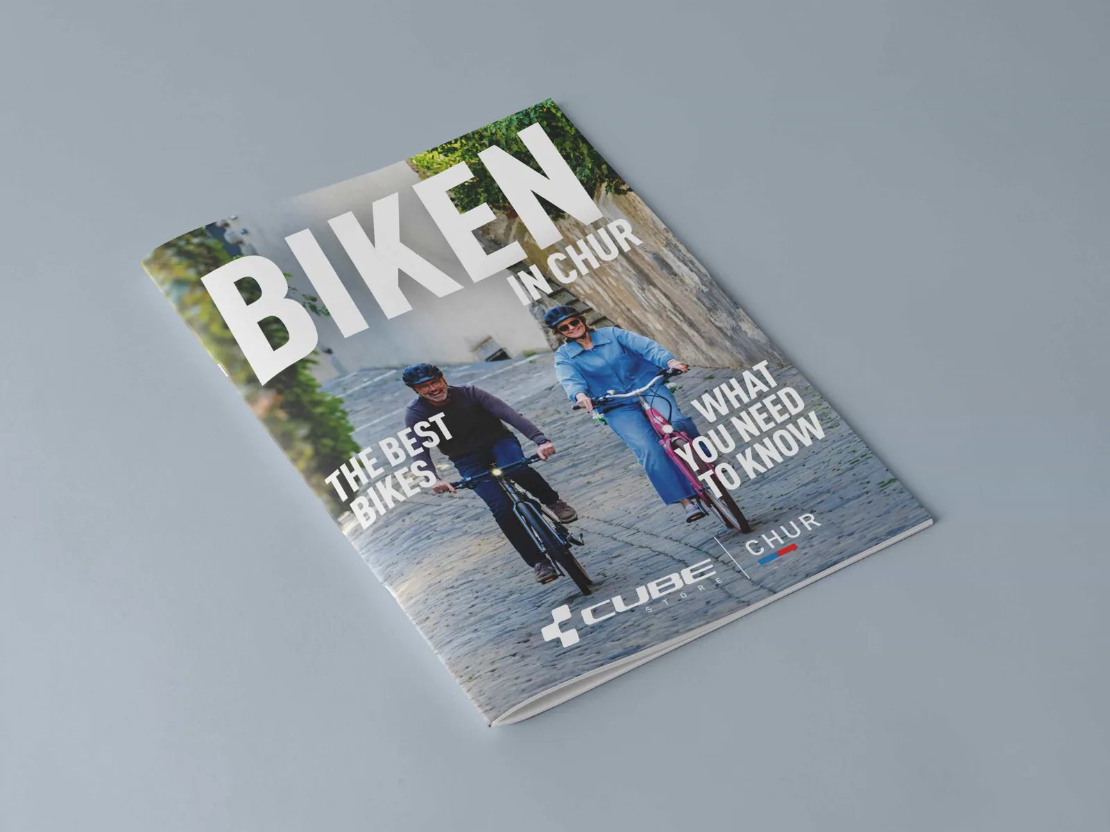 Das gedruckte Kundenmagazin „Biken in Chur“, aufgeschlagen und als Titel.