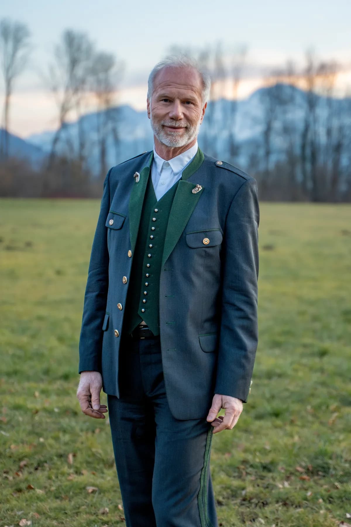 Peter Ladreiter in ganzer Figur im Trachtenanzug auf der Wiese.