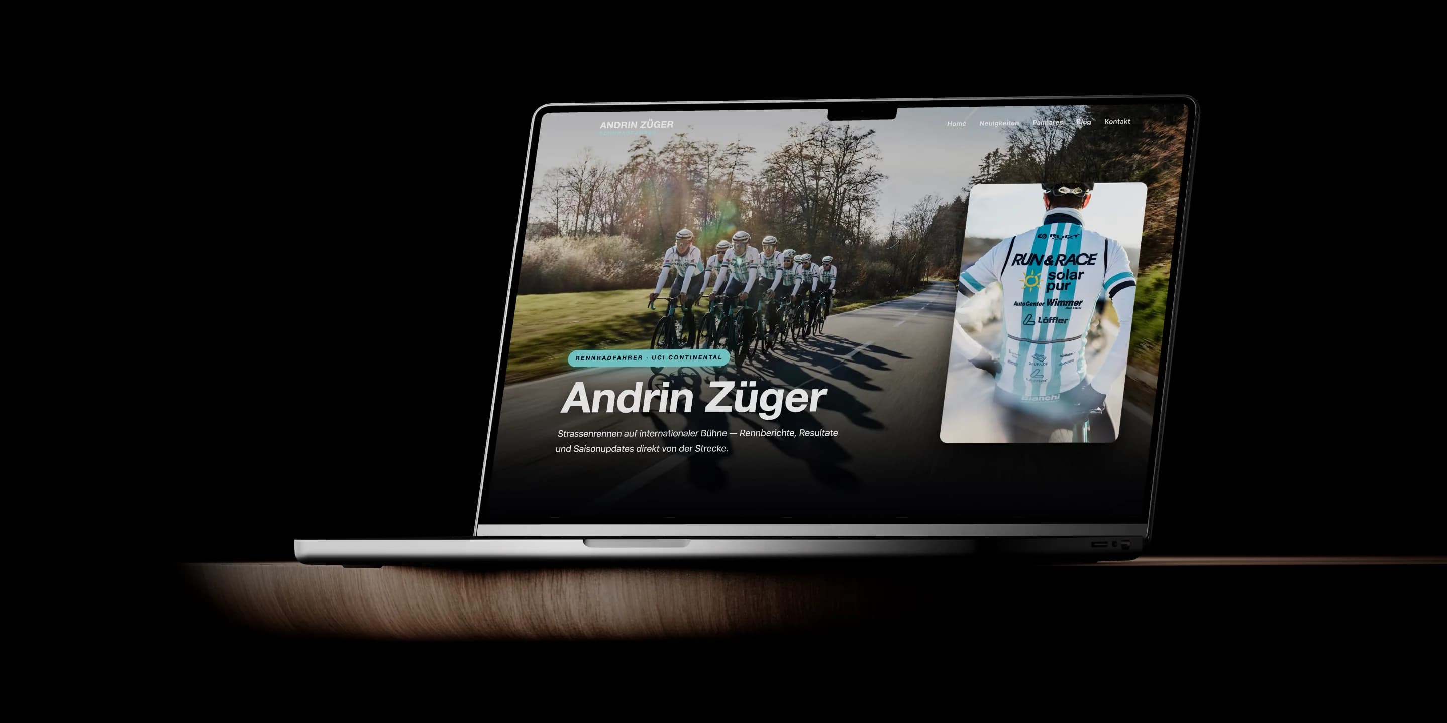 Webentwicklung: Ein MacBook auf einer Holzfläche im dunklen Studio zeigt die Startseite von andrinzueger.ch mit der Fahrergruppe und dem Namen Andrin Züger.