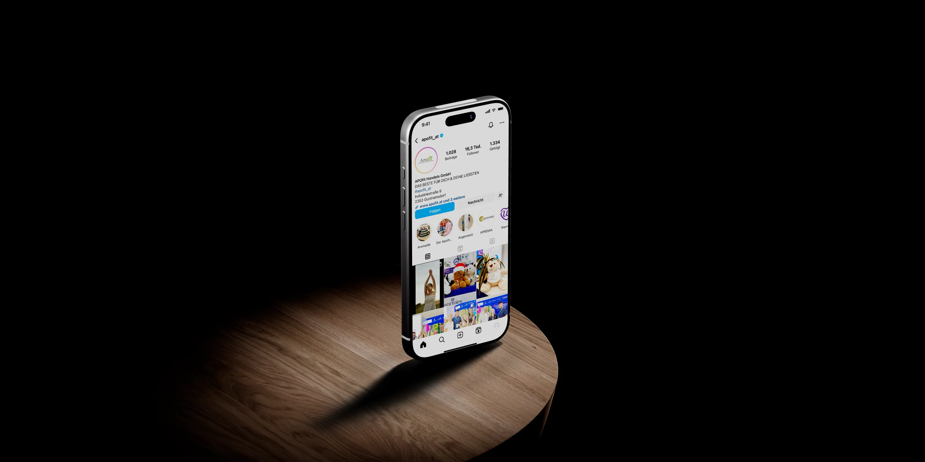 Social Media für APOfit: Ein iPhone auf einem Holztisch zeigt das Instagram-Profil apofit_at mit seinen Beiträgen.