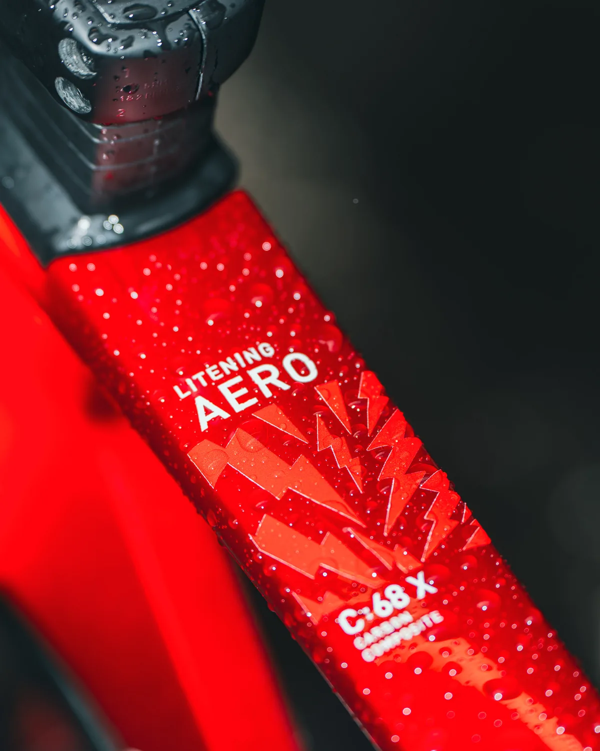 Ein rotes Rahmenrohr des CUBE Litening Aero von nahem, voller Wassertropfen, mit Blitzgrafik und dem Schriftzug Litening Aero C:68X.