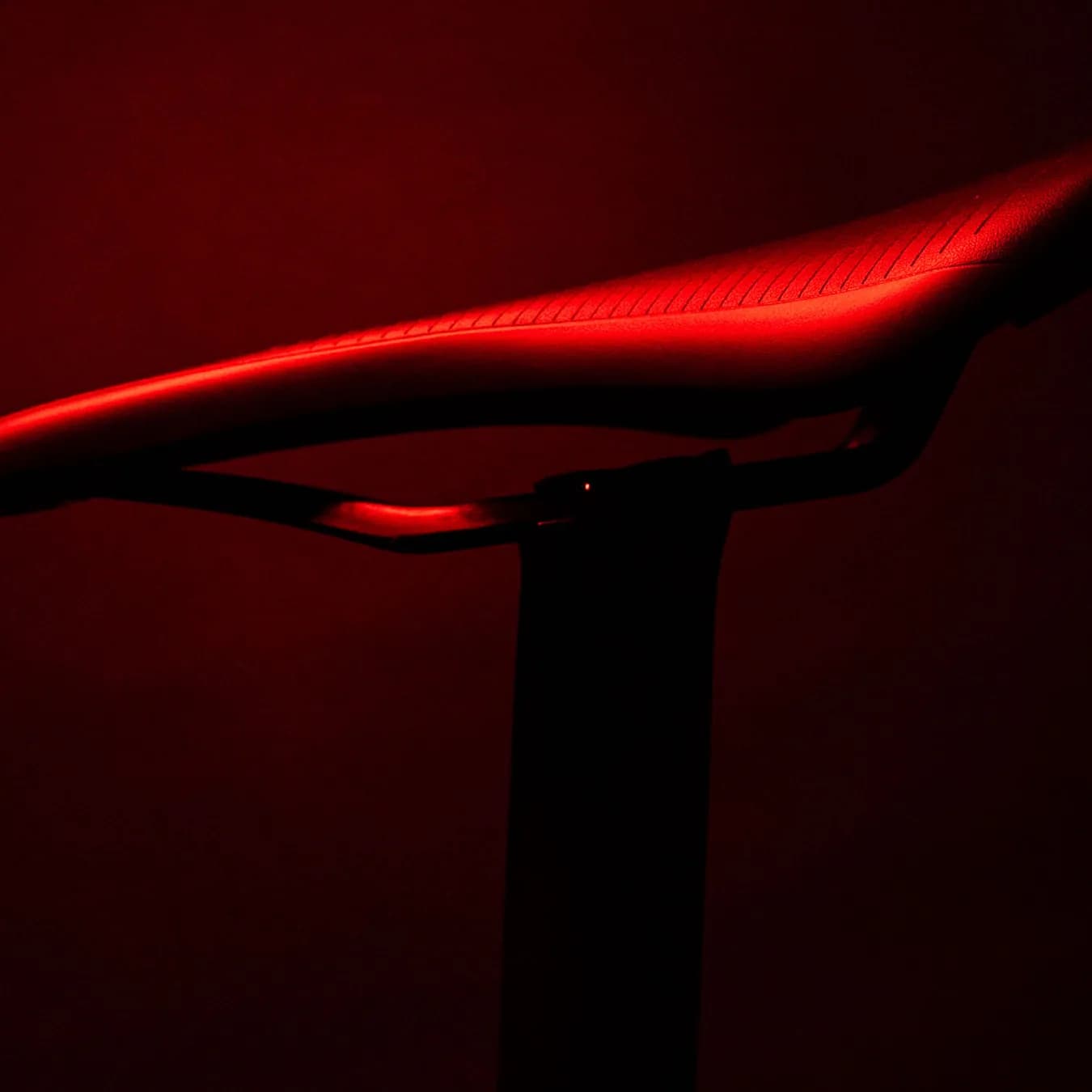Der Sattel des Litening Aero im Dunkeln, die Oberkante von rotem Licht nachgezeichnet.