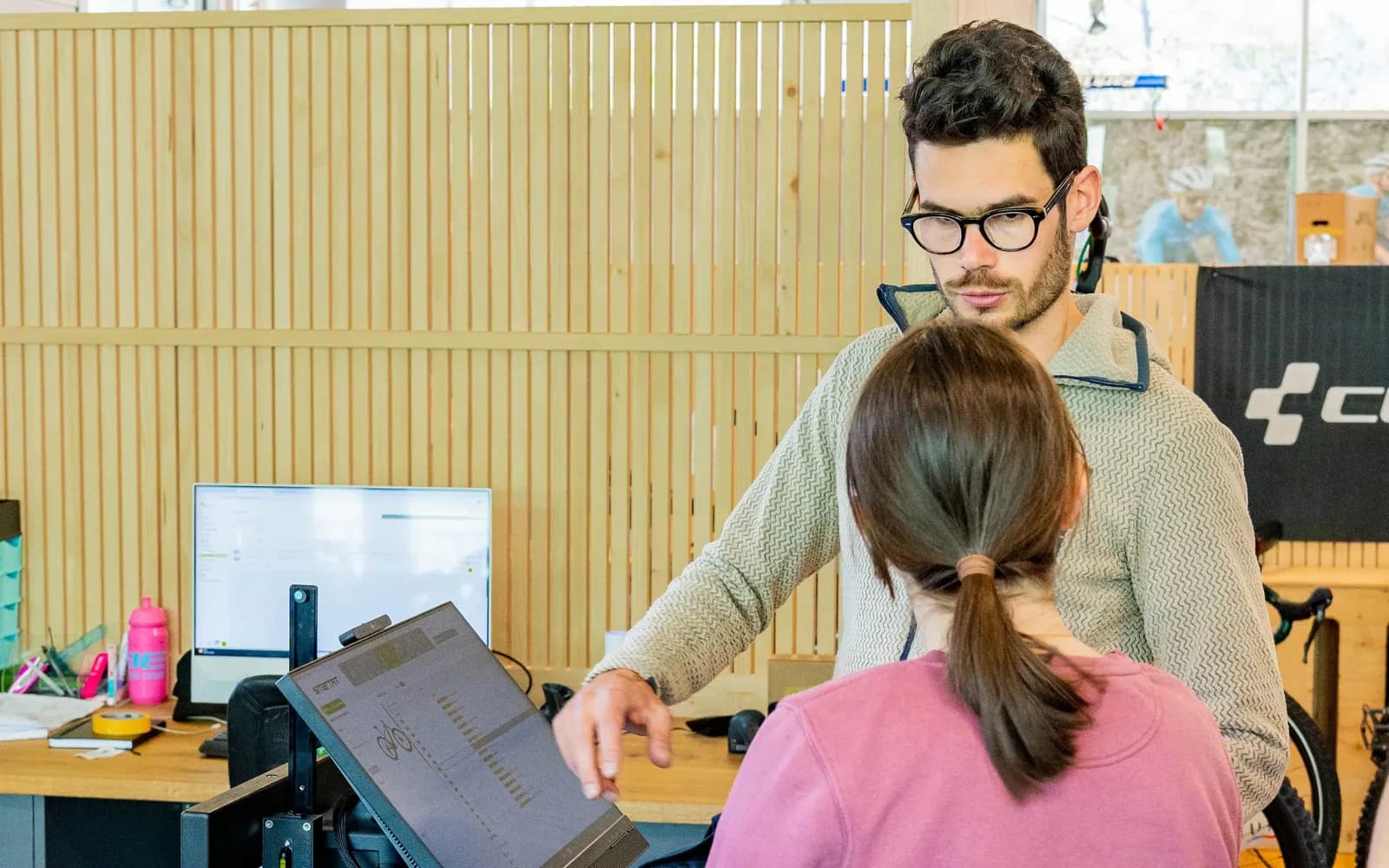 Ein Mitarbeiter des CUBE Store Chur berät eine Kundin an der Bike-Fitting-Station.