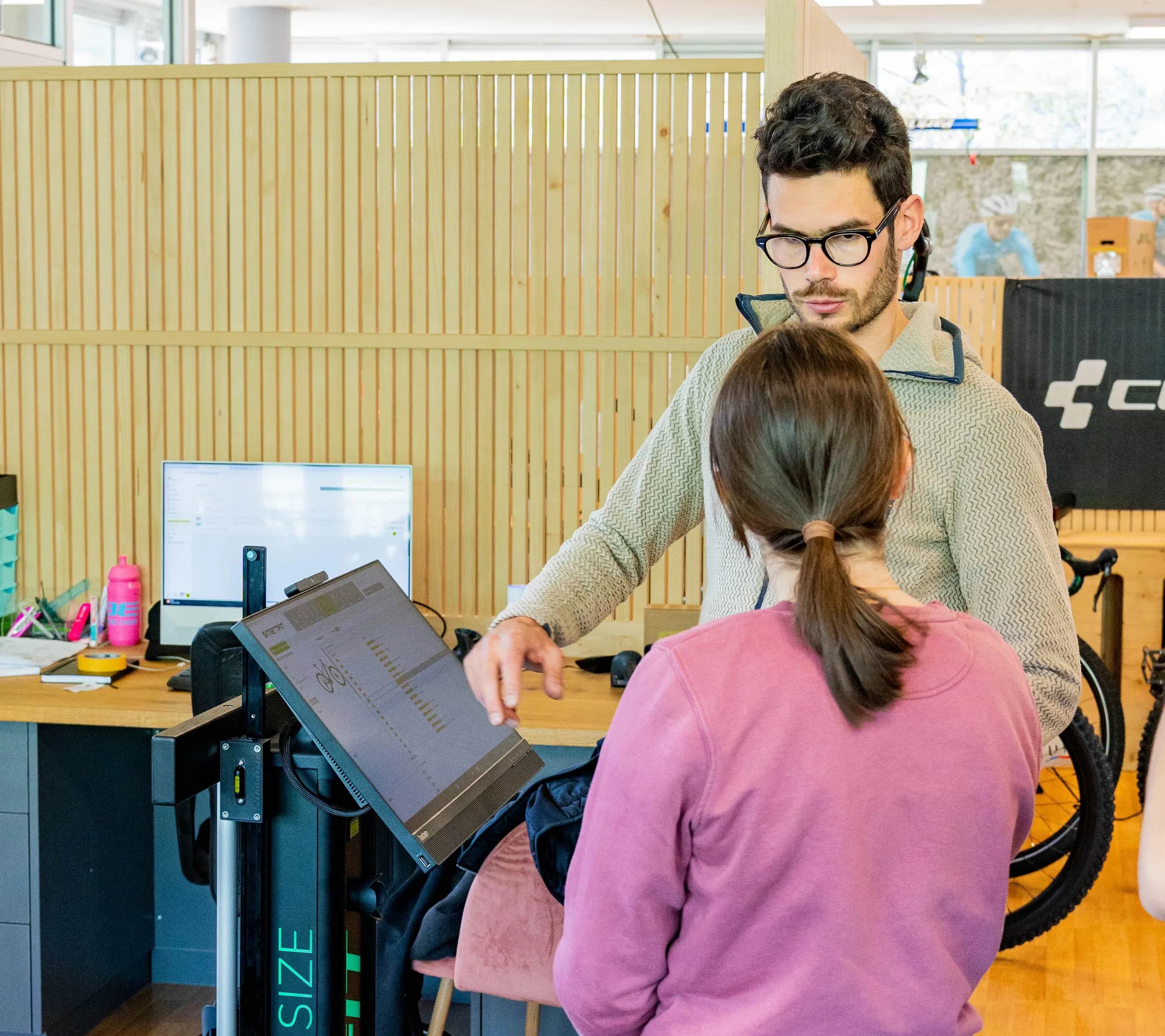 Beratung im CUBE STORE CHUR: ein Mitarbeiter vermisst eine Kundin an der Bike-Fitting-Station.