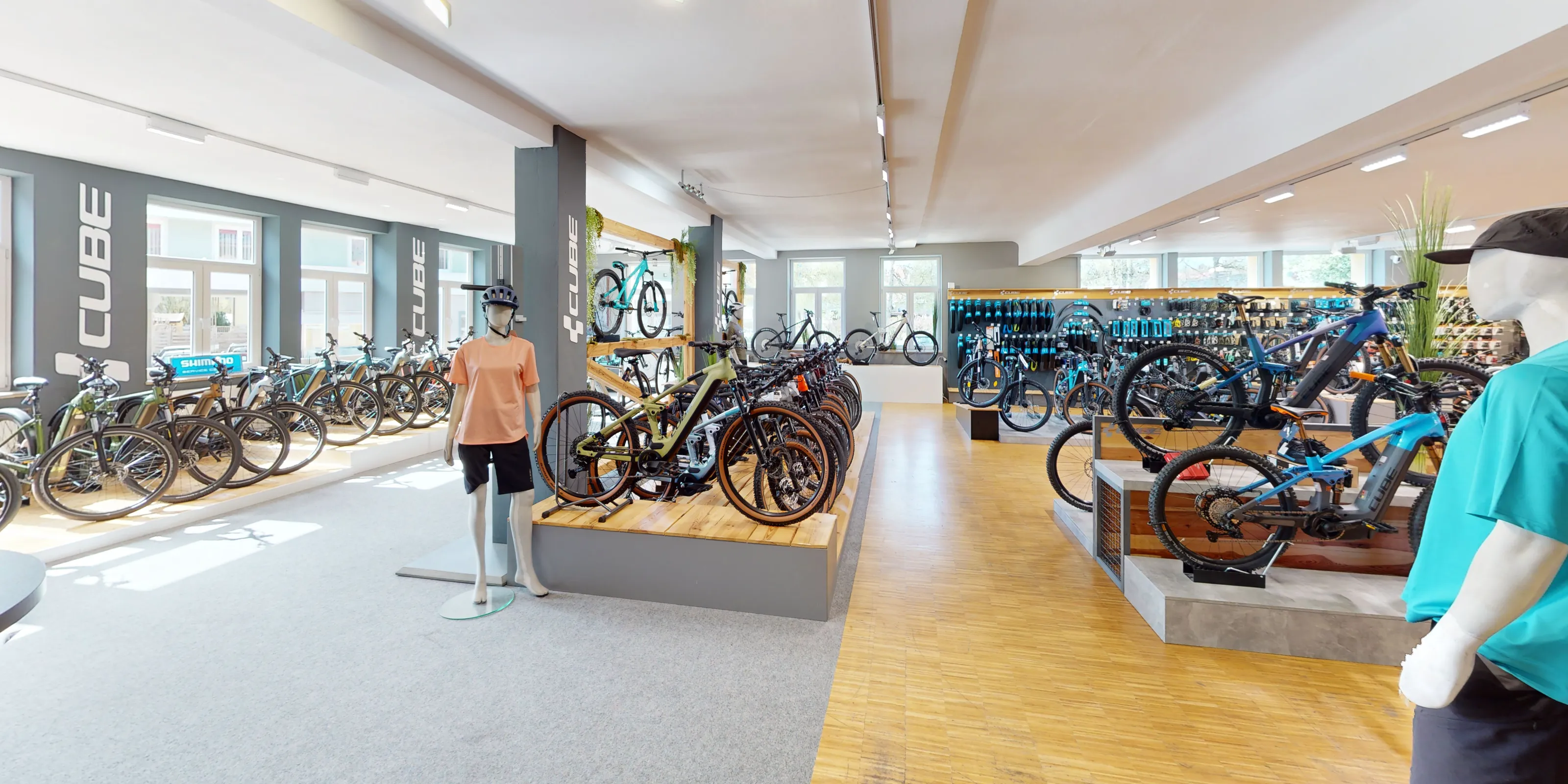 Marketing und Strategie für den CUBE Store Lindenberg: der Blick über die Verkaufsfläche mit den Rädern auf den Podesten und den CUBE-Schriftzügen auf den Pfeilern.
