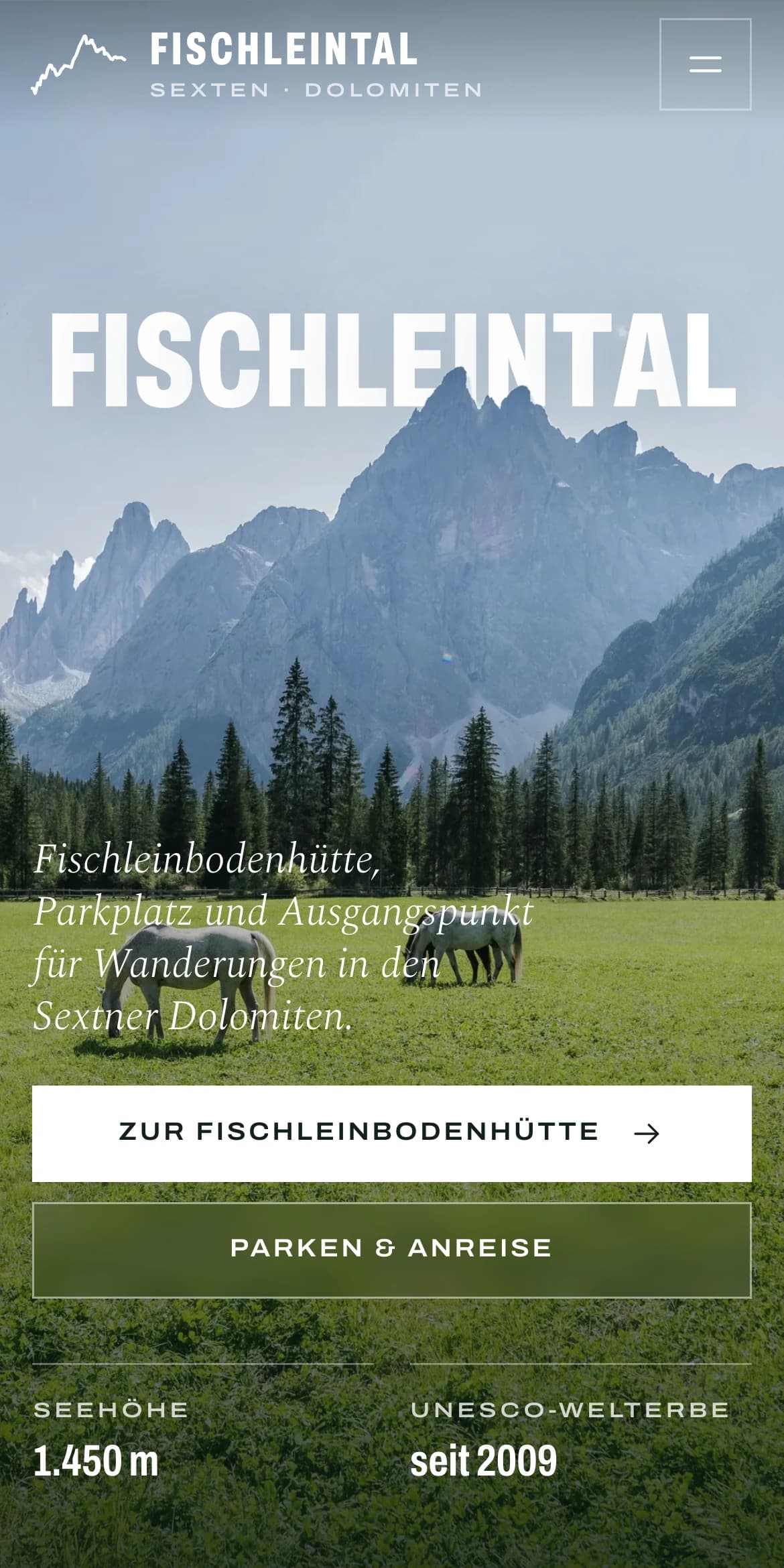 Ein aufgeklapptes MacBook im Dunkeln zeigt die Startseite von fischleintal-dreizinnen.it: der Schriftzug Fischleintal zwischen Himmel und Bergen, darunter eine Wiese mit zwei Pferden.