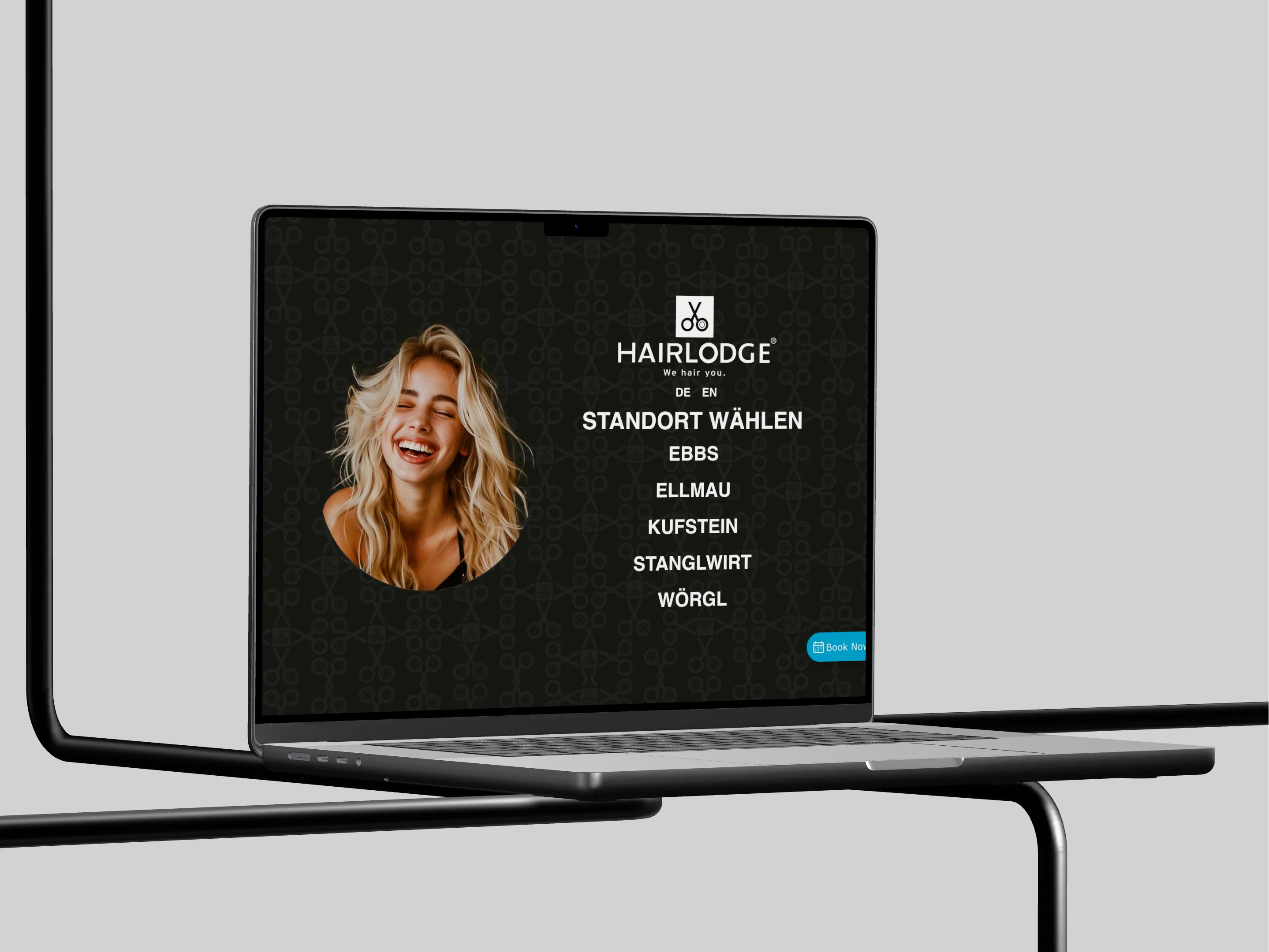 Die frühere Website von HAIRLODGE auf einem MacBook: eine dunkle Standortauswahl für Ebbs, Ellmau, Kufstein, Stanglwirt und Wörgl neben dem Foto einer Frau.