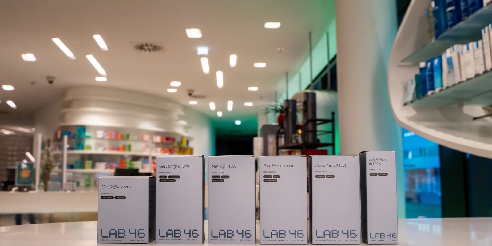 Der Verkaufsraum einer Apotheke: auf der runden Theke stehen die Kartons von LAB46, dahinter die Regalwand.