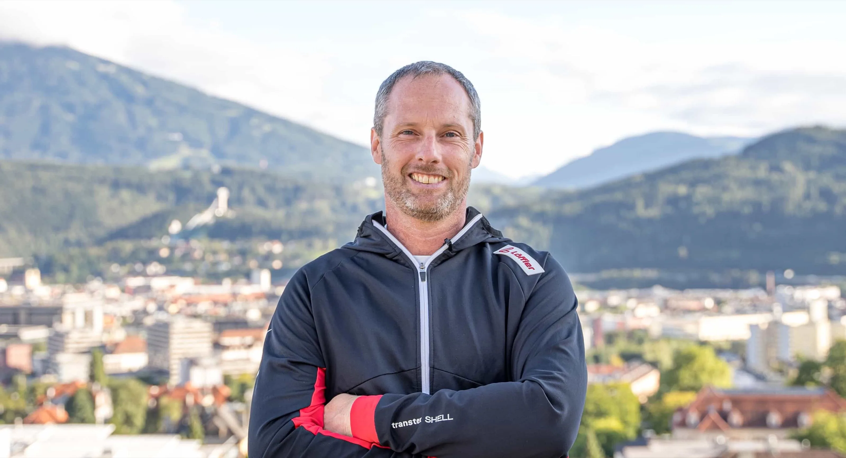 Robert Treitinger: Der Personal Trainer mit verschränkten Armen vor Innsbruck und der Nordkette.