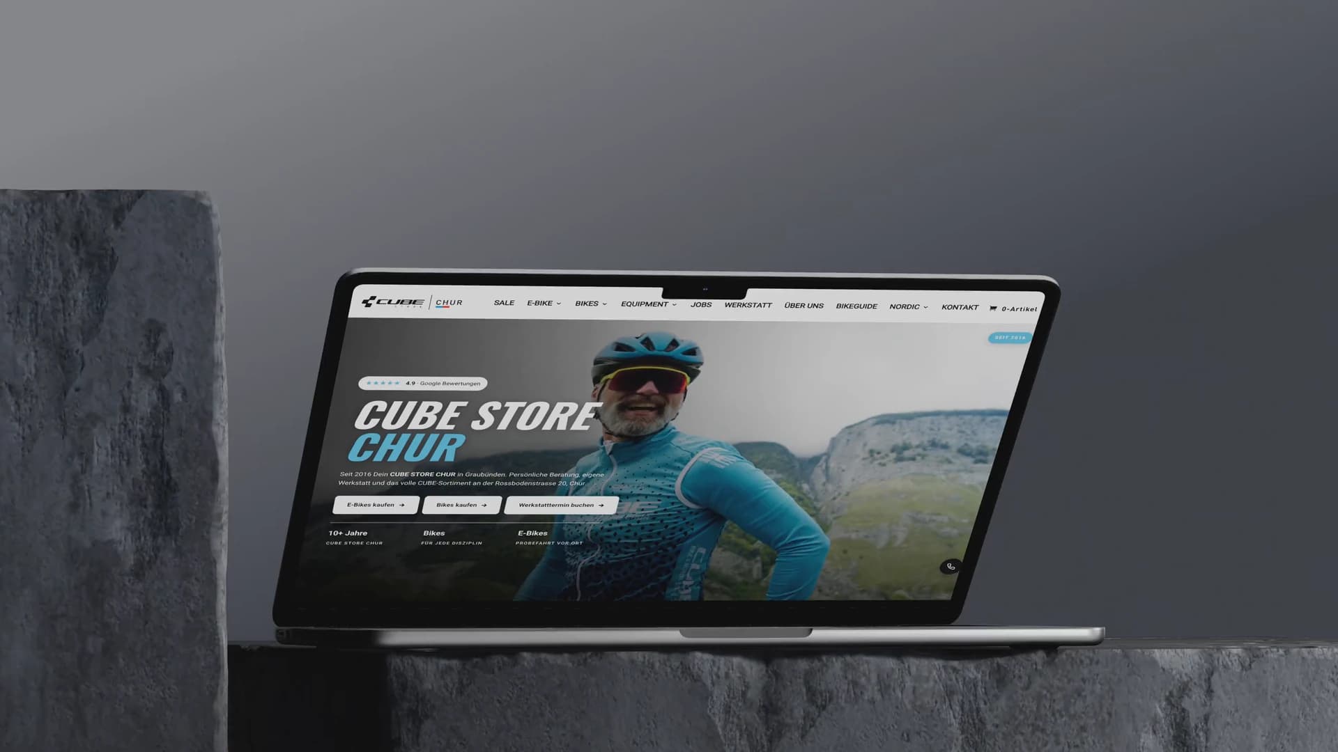 Eine Kamerafahrt um ein MacBook, auf dem die Startseite des CUBE STORE CHUR steht.