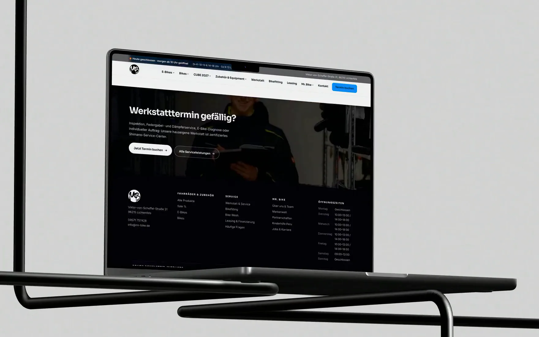 Eine Kamerafahrt um ein MacBook auf einem Drahtgestell, auf dem Schirm läuft die Startseite von mr-bike.de durch.