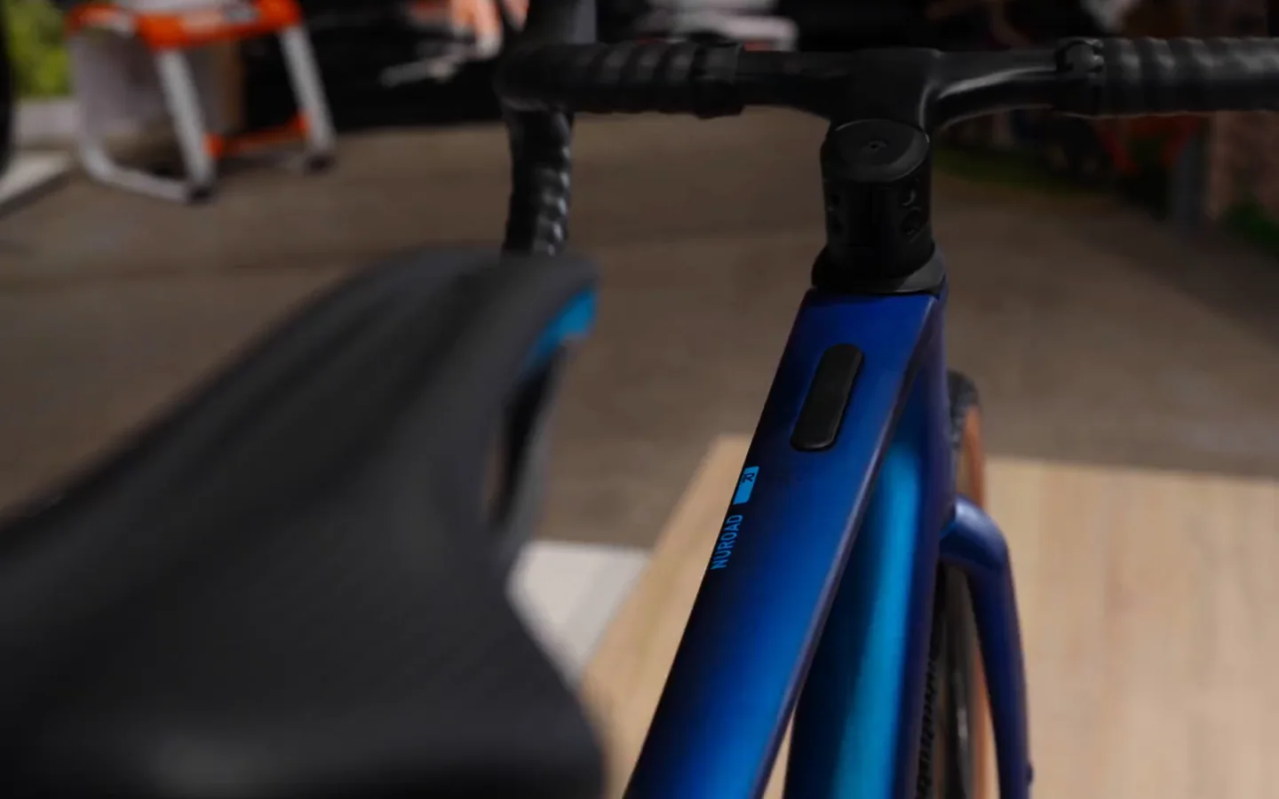 Die Modellvorstellung des CUBE Nuroad C:62 Race: ein Verkäufer zeigt das blaue Gravelbike im Verkaufsraum, dazwischen Nahaufnahmen von Rahmen, Schaltung und Reifen, untertitelt.