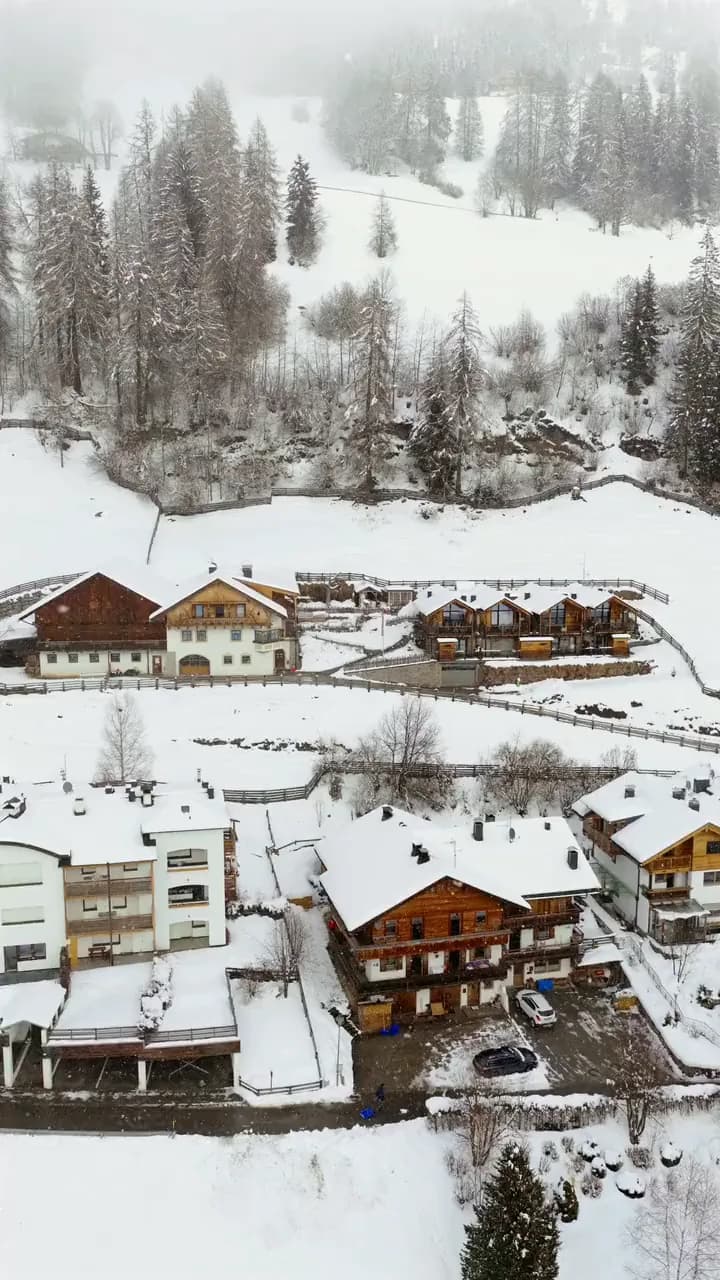 Der Imagefilm für den Stabinger Hof im Hochformat: der Blick aus der Luft über die verschneiten Chalets hinaus auf das Dorf Sexten.