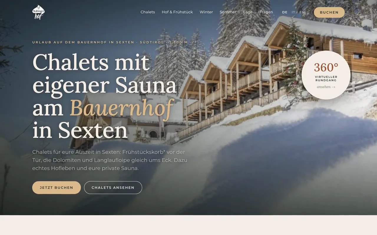 Die Startseite von stabingerhof.it öffnet sich: über verschneiten Chalets erscheinen die Überschrift und die Knöpfe zum Buchen, dann läuft die Seite nach unten zu den Chalets.