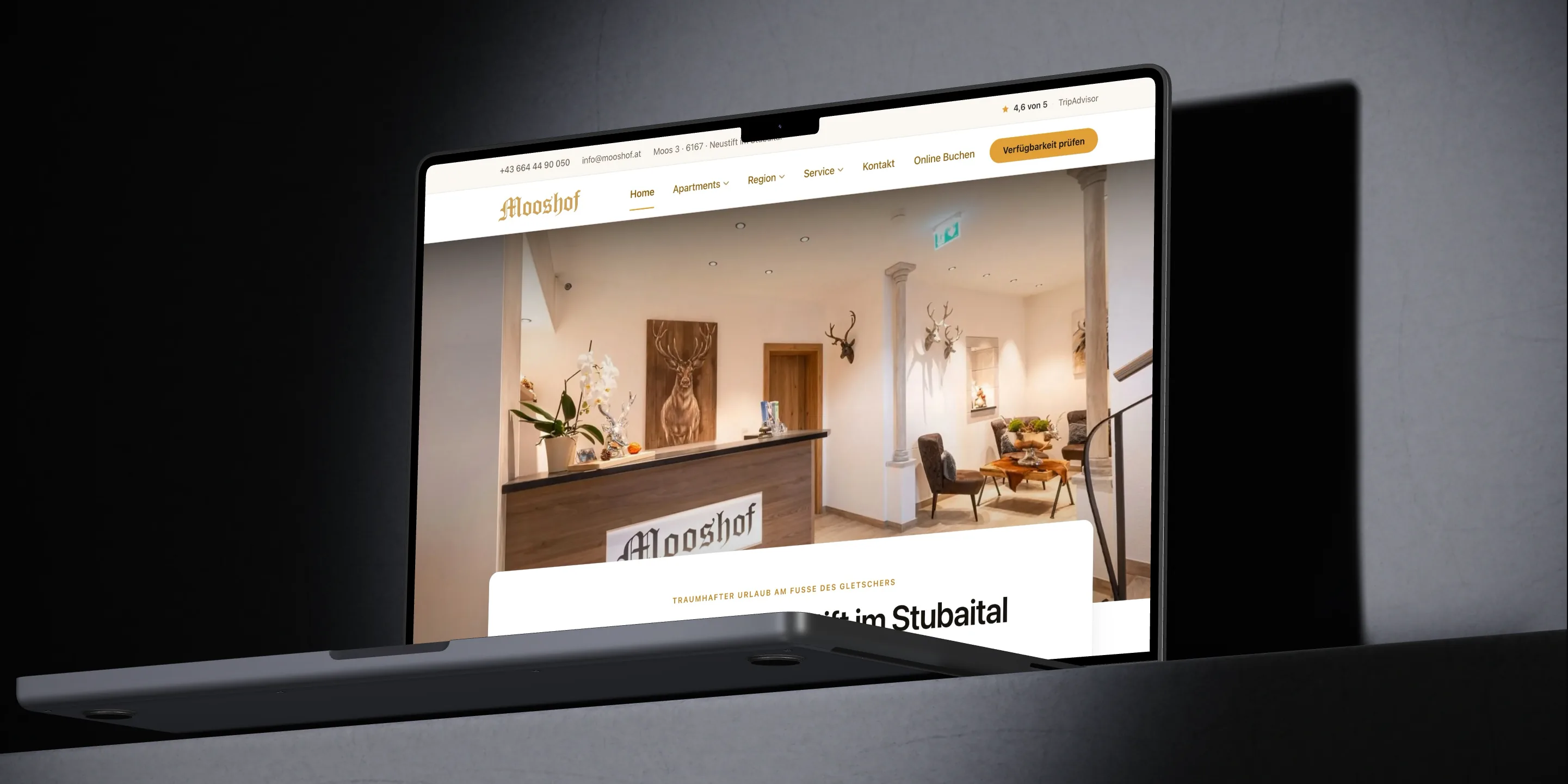Apartmenthaus Mooshof: Ein MacBook Pro zeigt die Startseite von mooshof.at mit der Rezeption des Hauses und dem Titel Apartments in Neustift im Stubaital.