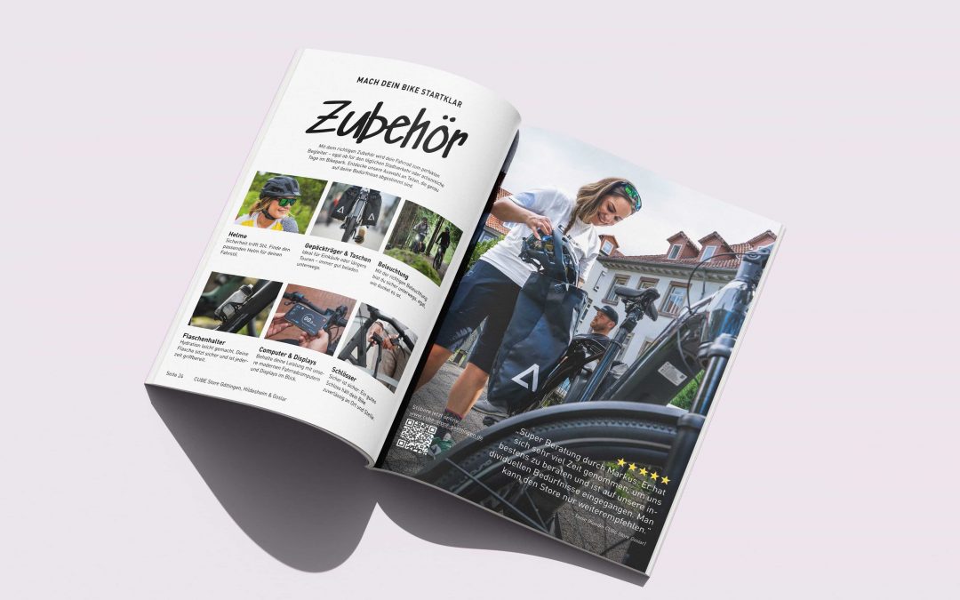 Aufgeschlagene Zeitschrift mit einer Doppelseite mit Fahrradzubehör auf der linken Seite und einem Foto einer Frau in Fahrradkleidung mit ihrem Fahrrad auf der rechten Seite. Text und Bilder heben verschiedene Fahrradprodukte hervor.