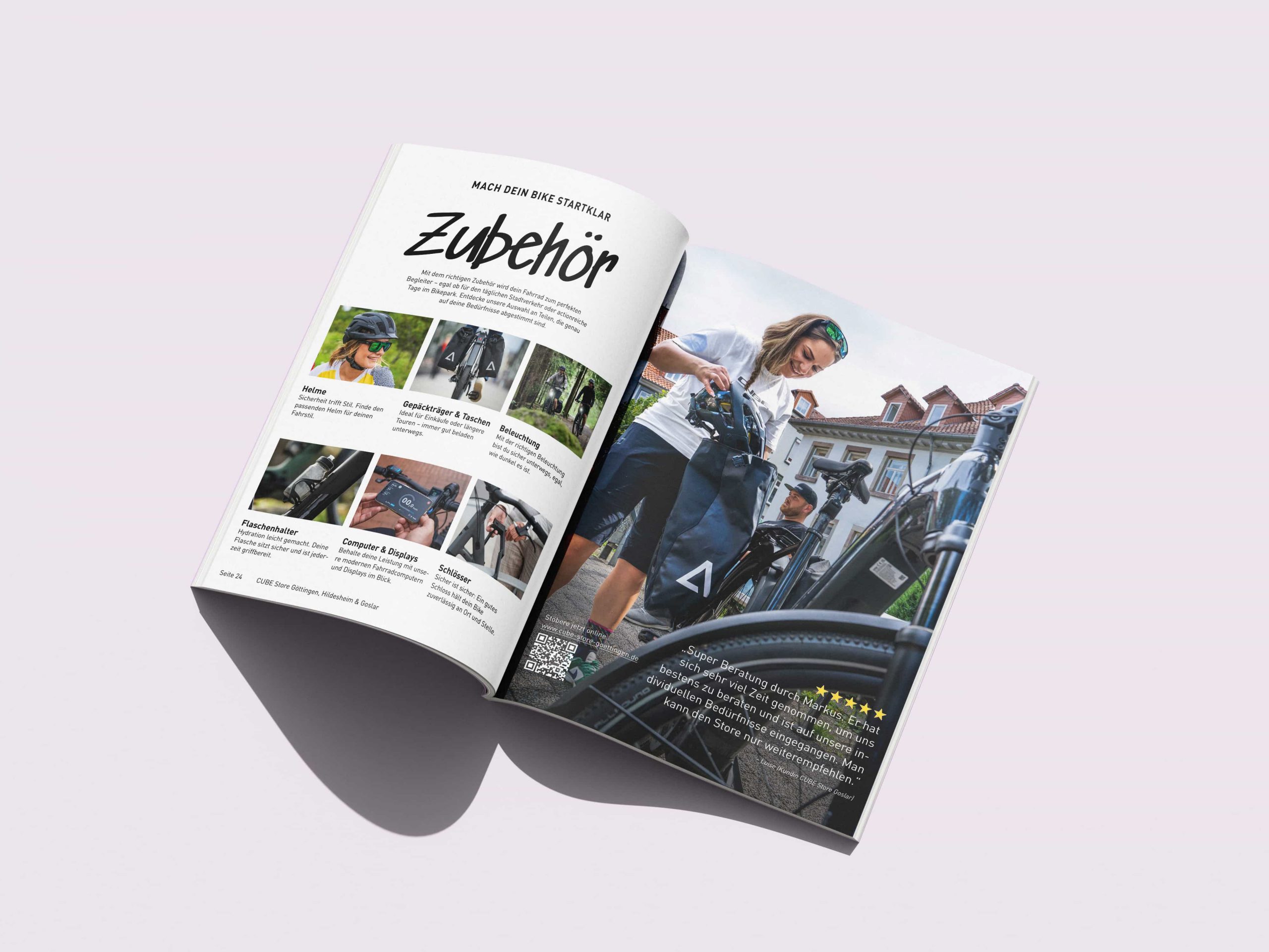 Ein aufgeschlagenes Magazin auf einer hellen Fläche zeigt links eine Seite mit Fahrradzubehör in deutscher Sprache und rechts ein Foto einer Frau in Fahrradkleidung mit ihrem Fahrrad, die im Freien in der Nähe von Gebäuden steht.