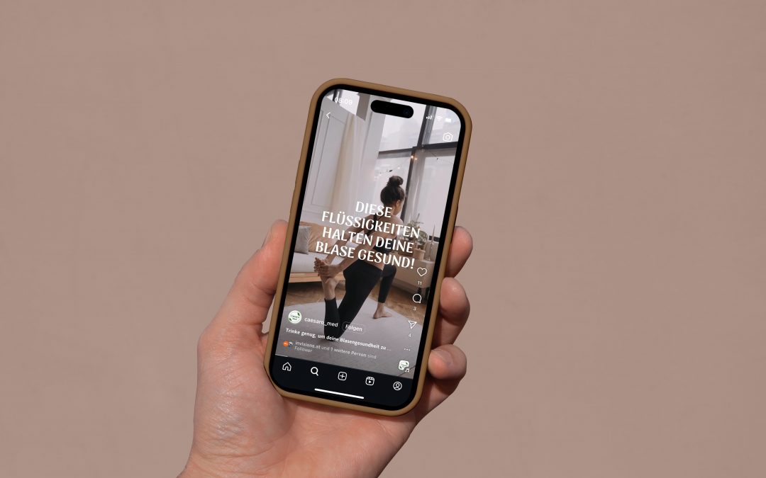 Eine Hand hält ein Smartphone, auf dem ein Social-Media-Post einer Frau in Trainingskleidung zu sehen ist, die sich vor einem Fenster dehnt. Der deutsche Text auf dem Bild spricht über gesunde Flüssigkeiten für die Blase.