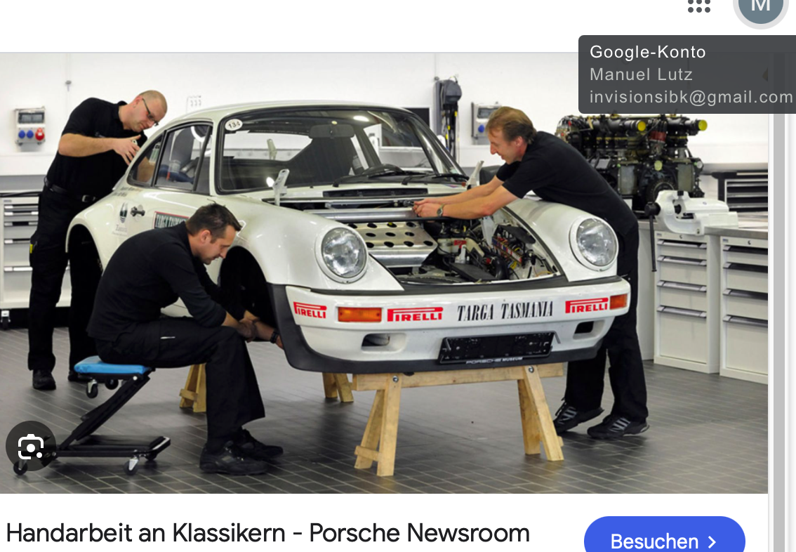 Drei Mechaniker arbeiten an der Restaurierung eines klassischen weißen Porsche 911 in einer sauberen, modernen Werkstatt. Das Auto steht auf Ständern, der vordere Kofferraum ist geöffnet und verschiedene Werkzeuge und Teile sind um sie herum zu sehen.