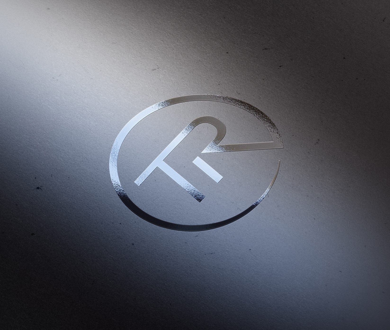 Logo-Brand-Mockup-Presentation Metallisch geprägtes Logo auf einer strukturierten grauen Oberfläche, mit stilisierten Buchstaben F und R, die in einem Teilkreis verschmolzen sind, beleuchtet von einem weichen Licht von links oben.