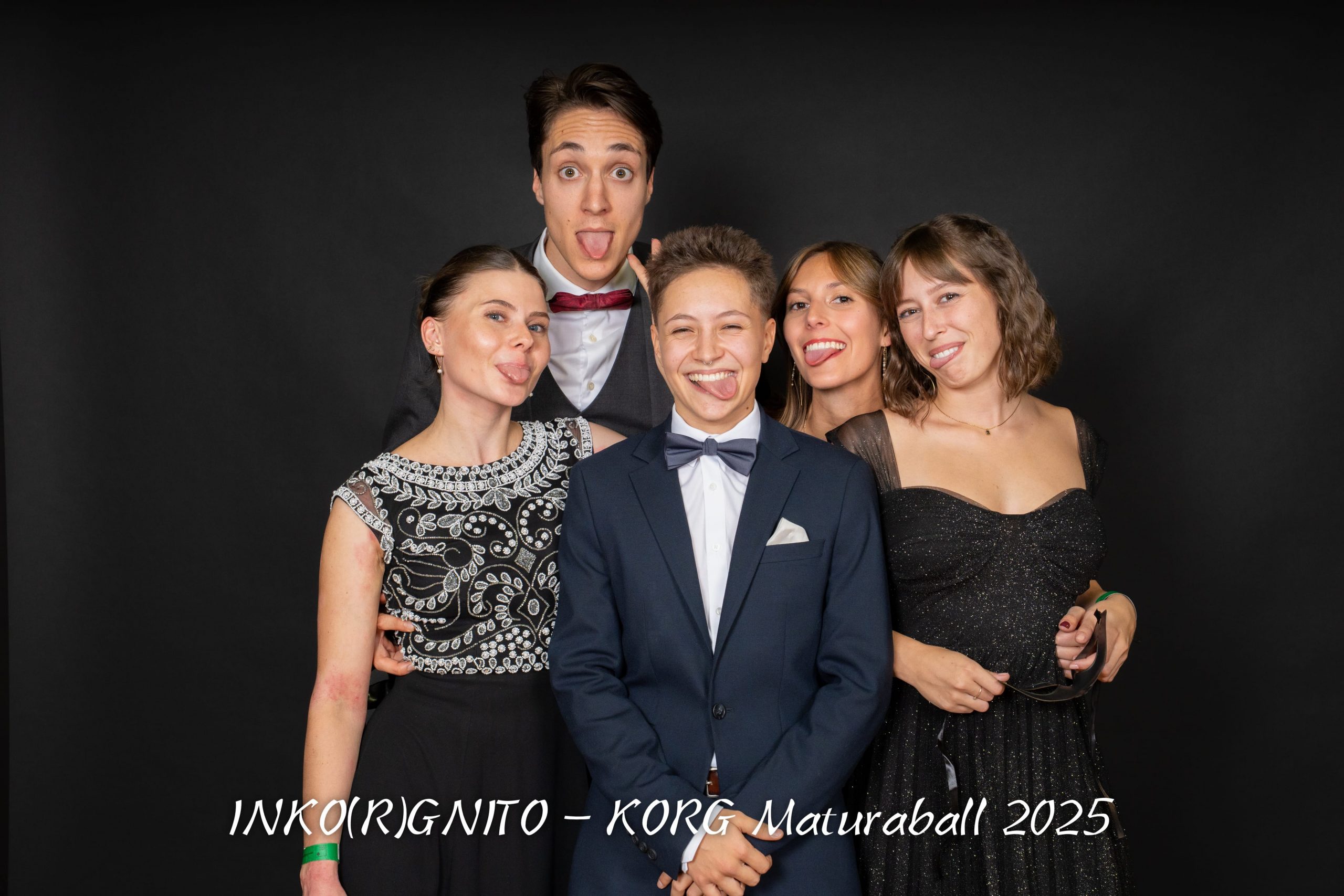 Fünf förmlich gekleidete junge Erwachsene posieren und lächeln spielerisch vor einem schwarzen Hintergrund. Einige machen alberne Grimassen. Der Text am unteren Rand lautet: "INKO(R)GNITO - KORG Maturaball 2025".